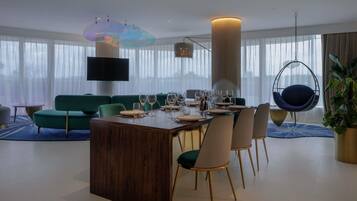 A modern dining area with a wooden table, chairs, and a hanging chair.