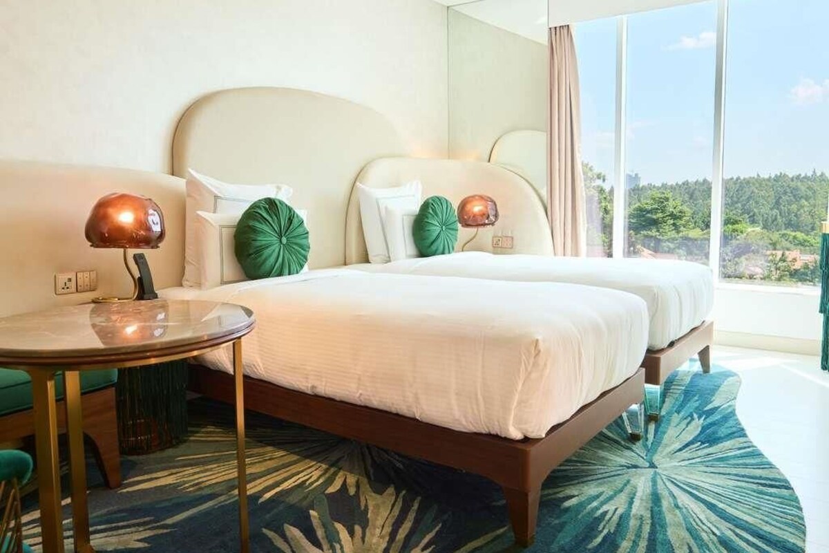 A hotel room with a bed, a round table, and a view of the outdoors.