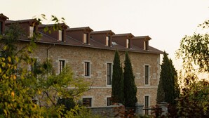 A stone building with multiple windows and a tiled roof, surrounded by greenery. - Hotel Fort St Laurent Lyon - Handwritten Collection (Lyon)