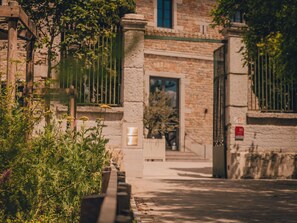 A stone building with a gated entrance, a small window, and a door. - Hotel Fort St Laurent Lyon - Handwritten Collection (Lyon)