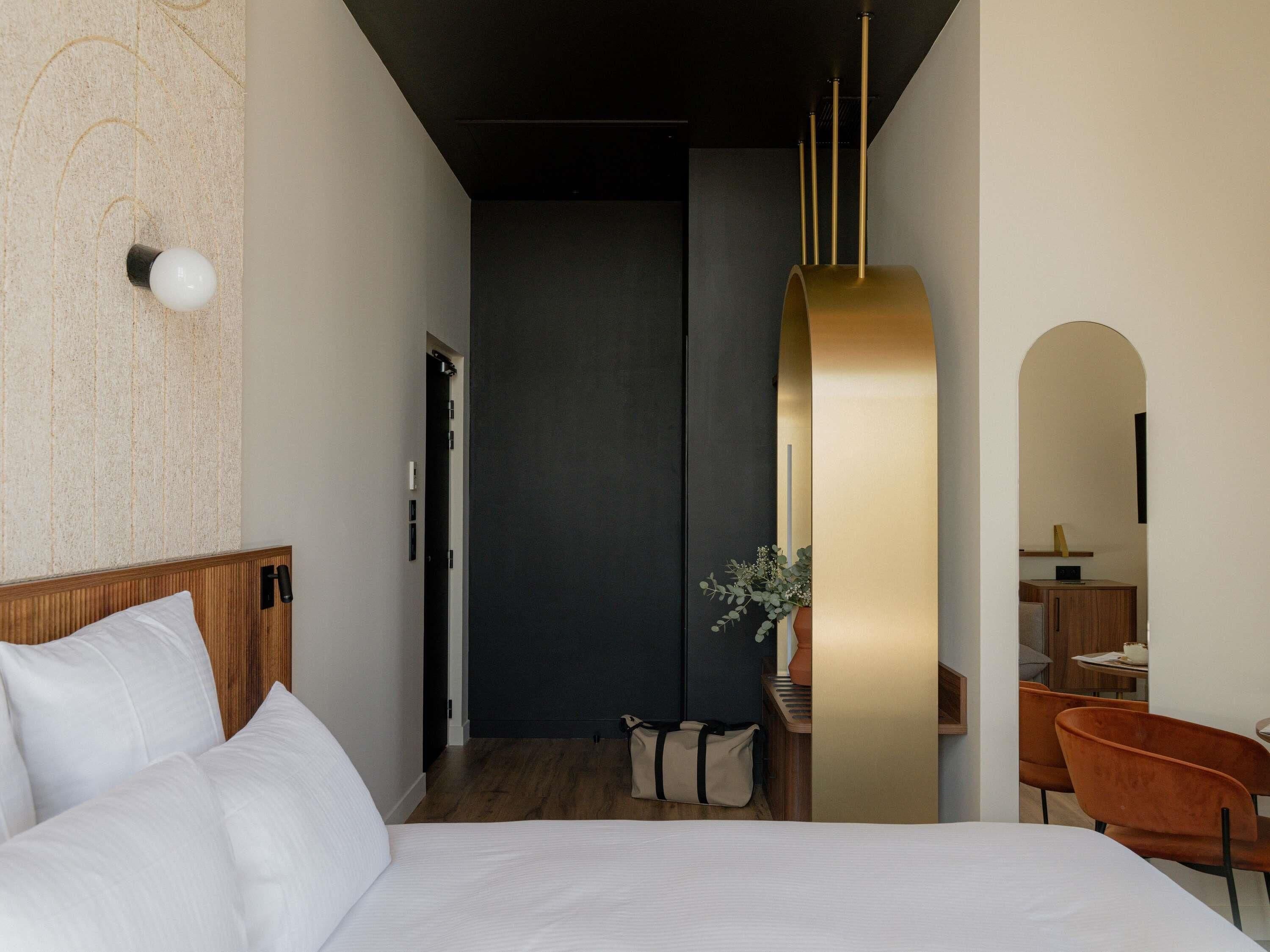 Una habitación de hotel moderna con una cama grande, un escritorio y una zona de estar.