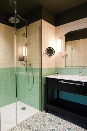 A bathroom with a shower, a sink, and a mirror.