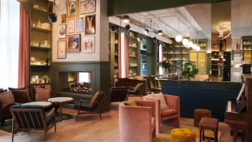 A cozy lounge area with seating, a fireplace, and a bar with shelves.