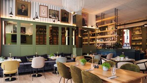 A restaurant with a bar area, green walls, and shelves with bottles. - Square Lodge Hotel La Roche Sur Yon - Handwritten Collection (La Roche-sur-Yon)