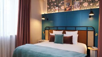 Una cama bien hecha con cabecera, una mesita de noche y una pared con estampado floral.
