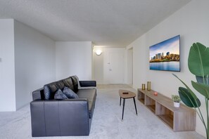Business Apartment | Living area | 50-inch Smart TV with cable channels, books