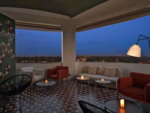 A rooftop terrace with a sofa, chairs, tables, and a lamp. - Novotel Lubumbashi (Lubumbashi)