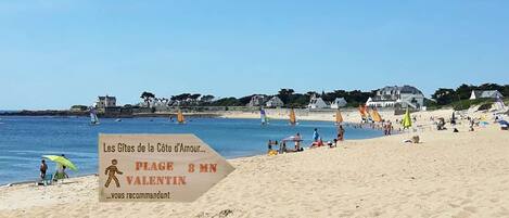 A beach with a sign indicating the location as 'PLAGE 8 MN VALENTIN.'