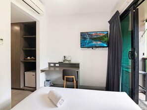A hotel room with a bed, a desk, a chair, a TV, and a view of a mountain landscape. - Ibis Darwin Airport Hotel (Eaton)