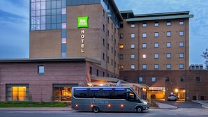 A hotel with a modern design, featuring a curved glass facade and a brick lower section.