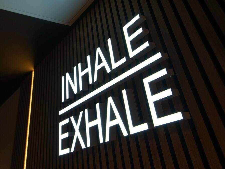 A wall with a sign that reads 'INHALE EXHALE'.