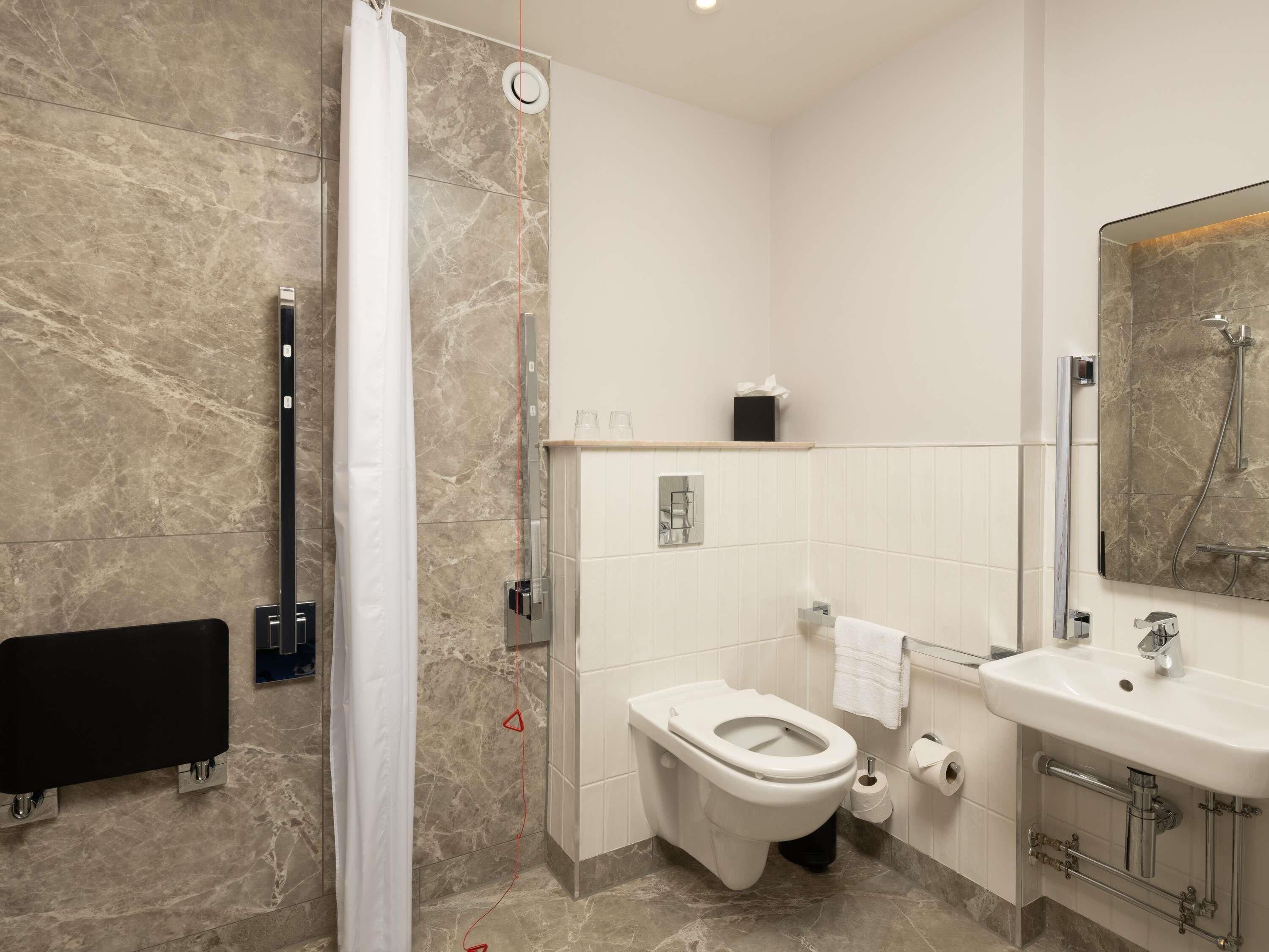 Un baño moderno con ducha, inodoro y lavamanos.