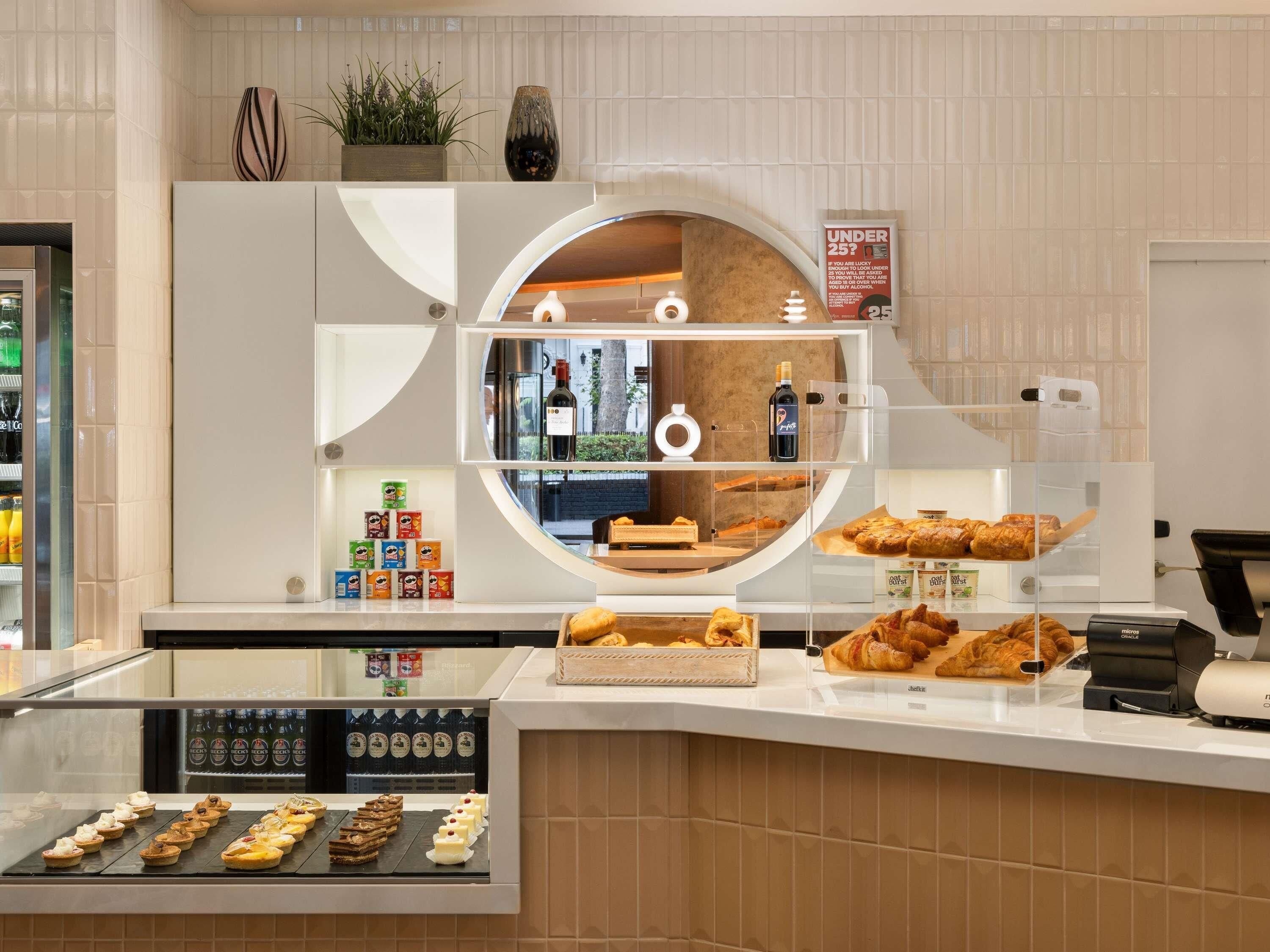 A bakery display with pastries, a refrigerator with beverages, and a sign indicating a discount for under 25.