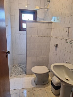 Een badkamer met toilet, bidet en wastafel.