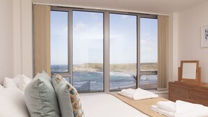 A bedroom with a large window offering a view of the beach and ocean. - A large three bedroomed apartment in West Pentire, Crantock. (Crantock)