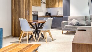 Una cocina moderna con armarios de madera, una mesa de comedor con sillas y un sofá gris.