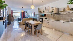 A modern kitchen with a dining area, large windows, and a view of the city. - Designer, fully equipped 3BR home in Gzira w/WIFI (Il-Gżira)