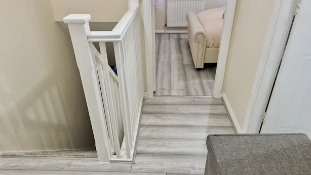 A staircase with a white railing leading to a room with a beige wall and a radiator. - London - Sleeps 4 - Parking - Garden - Petfriendly (London)