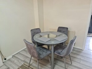 A round table with four grey chairs, a radiator, and a power outlet on the floor. - London - Sleeps 4 - Parking - Garden - Petfriendly (London)