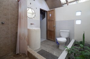 Bathroom with a toilet, sink, and small window.