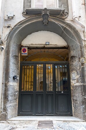 A black double door with a metal gate, a "No Parking" sign, and a small mailbox on the left. - Napoli Street Art Rooms - Wall by Wonderful Italy (Naples)