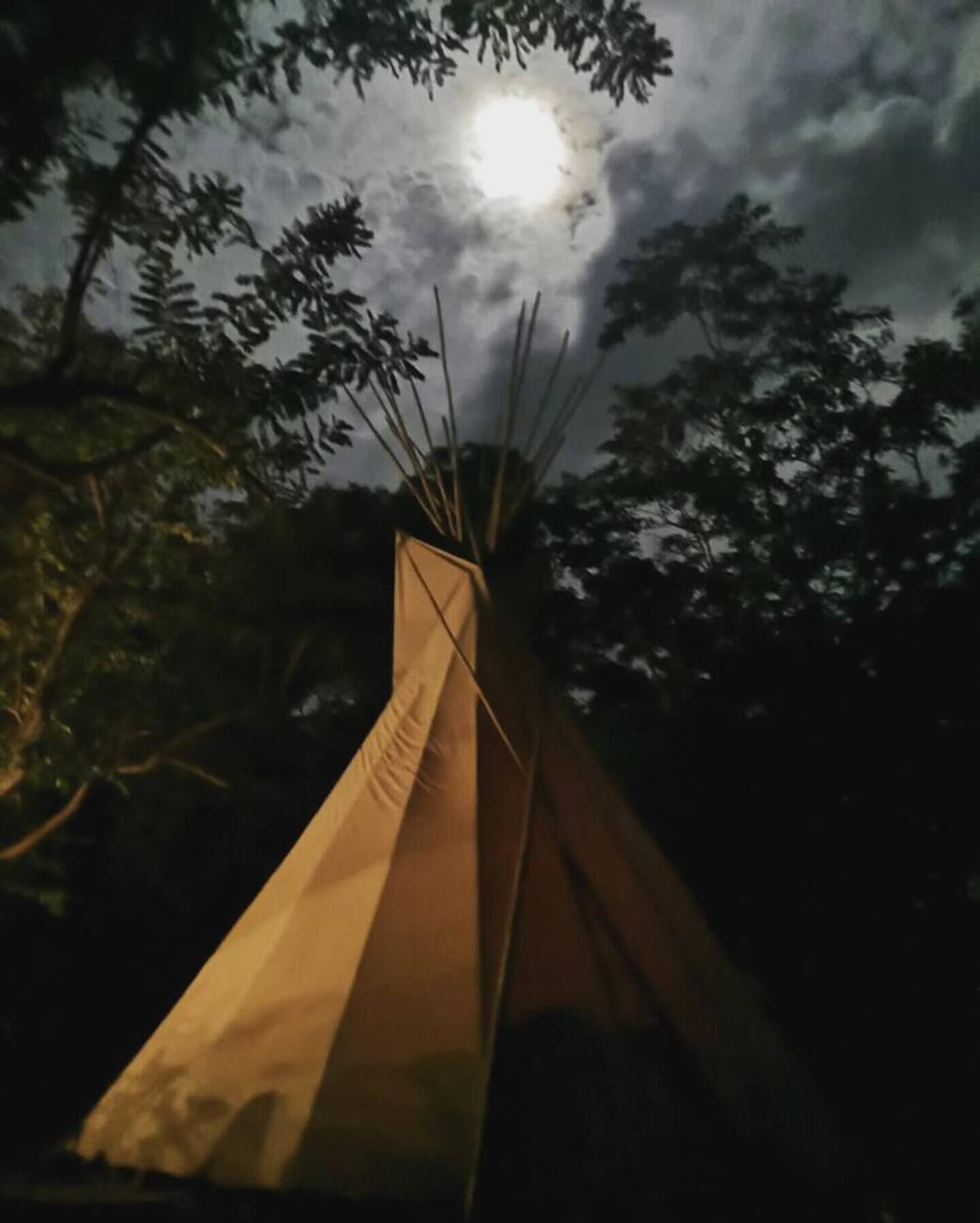 Un tipi con una entrada visible y la luna de fondo.