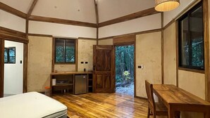 Une pièce spacieuse avec un plancher en bois, un lit, une table à manger et un coin cuisine intégré.