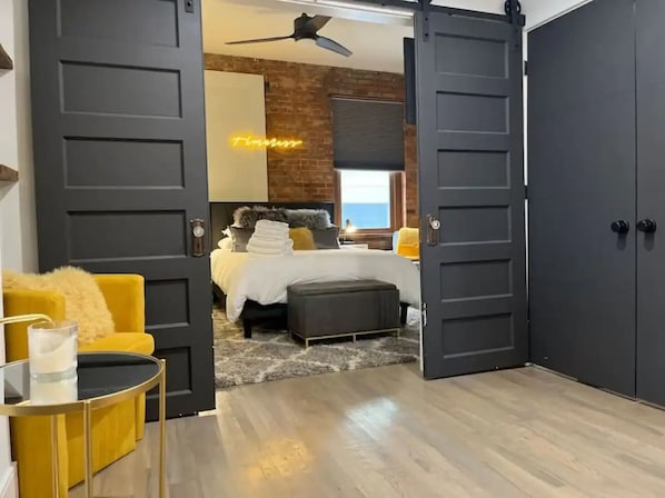 A modern bedroom with a bed, a yellow armchair, and a large wardrobe.