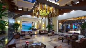 Eine geräumige Lobby mit einem großen Sitzbereich und Meerblick, sowie einer Rezeption.