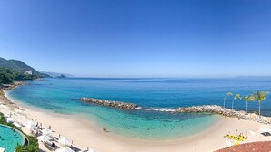 Ein Resort mit Strand, Schwimmbad und Bergblick.