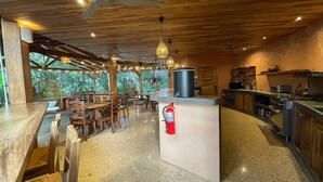Un restaurant avec des meubles en bois, un espace cuisine et un extincteur.
