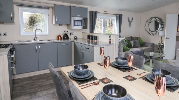 A modern kitchen with grey cabinets, a microwave, and a window.