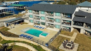 Un hotel con piscina, mobiliario exterior y vistas al agua.
