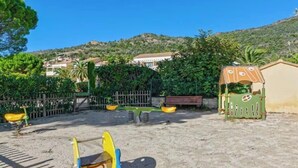 A playground with swings and a climbing structure. - L'Anse de Pramousquier, T2 Vue Mer ! Bord de plage (Le Lavandou)