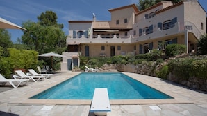 A large, two-story building with a swimming pool in the foreground.
