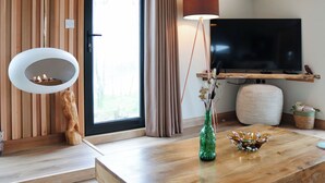 A modern living room with a fireplace, television, and wooden flooring.