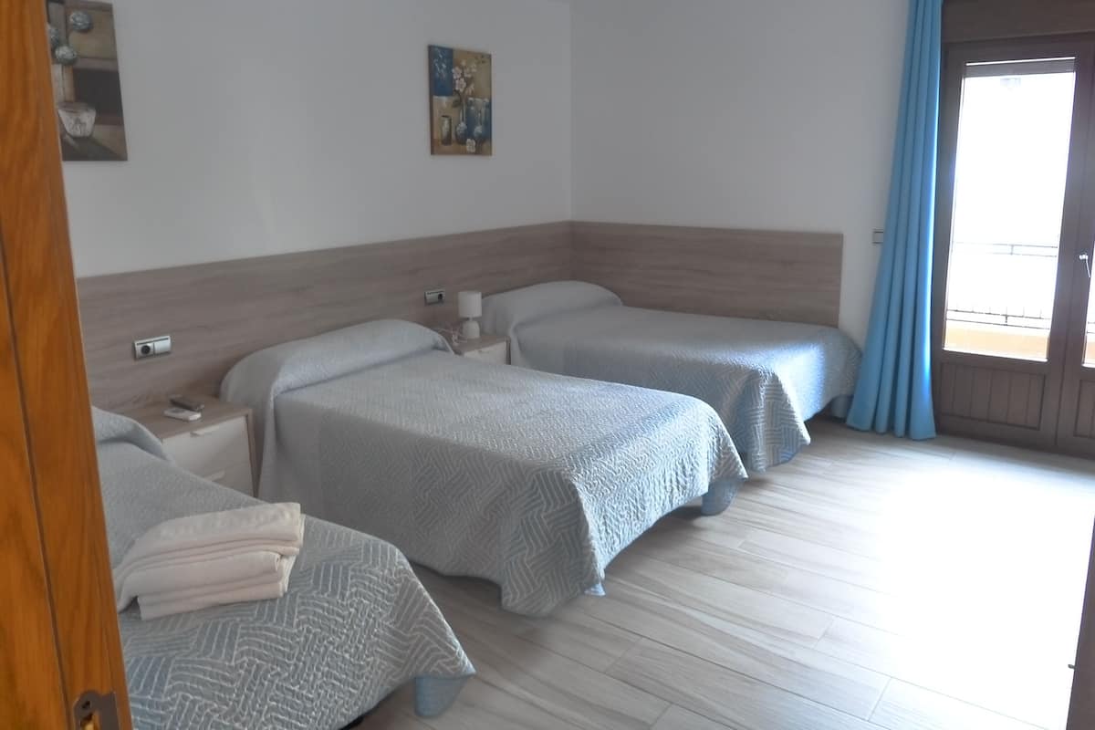 Ein Hotelzimmer mit zwei Betten, einem Holzkopfende, einem Nachttisch, einer Lampe und einem Gemälde an der Wand.