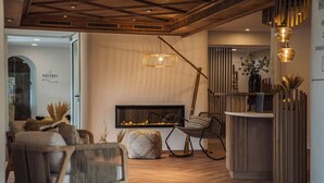 A cozy living room with a fireplace, comfortable seating, and a wooden ceiling. - Bergrose Hideaway (Strobl)