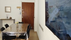 A conference room with a large table, chairs, a wooden door, and a large window with a view of a snowy landscape. - Cómodo, Amplio y Seguro Apartamento Familiar a Pasos del Metro en Buenos Aires (Buenos Aires)