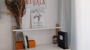 A desk with a computer, a vase with dried plants, and motivational wall art. - Cómodo, Amplio y Seguro Apartamento Familiar a Pasos del Metro en Buenos Aires (Buenos Aires)