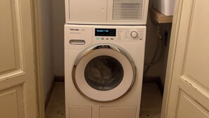 Een gestapelde wasmachine en droger in een wasruimte.