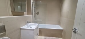 Appartement | Badkamer | Een bad/douchecombinatie, een diep bad, een haardroger, handdoeken