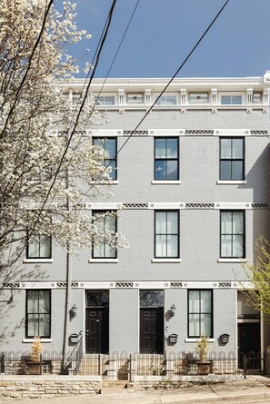 A multi-story building with a gray facade, black-framed windows, and a stone base. - Mulberry Mansion - OTR - FREE Parking (Cincinnati)