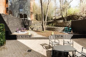 An outdoor patio with brick flooring, stone walls, and outdoor furniture. - Mulberry Mansion - OTR - FREE Parking (Cincinnati)