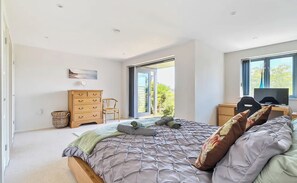 A bedroom with a bed, a dresser, a chair, a desk, and a window.