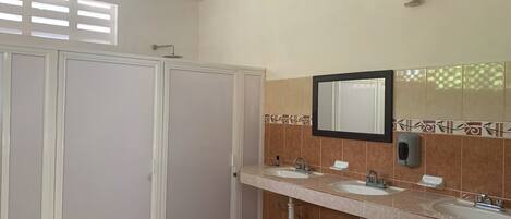 A bathroom with two sinks, a mirror, and a shower enclosure.