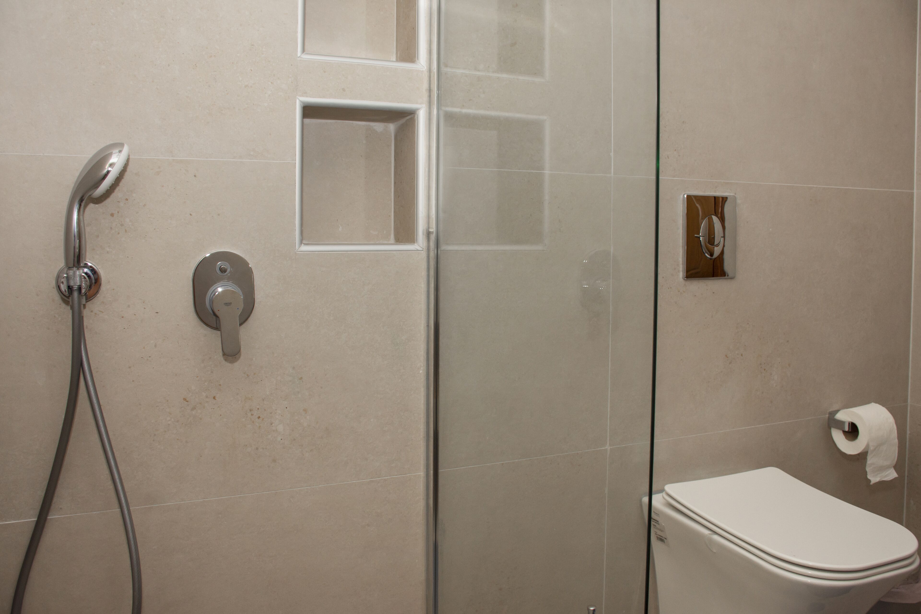 Ein Badezimmer mit Dusche, Toilette und einer Glasabtrennung.
