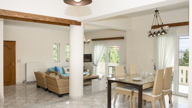 A spacious living area with a dining table, chairs, a sofa, and a television. - Christina Apartment 2nd Floor (Kissamos)