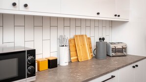 A kitchen with white cabinets, a microwave, a toaster, and wooden cutting boards. - Heart of the City, Beautiful 3 bed 2 Bath, Sleep 6 (Lincoln)