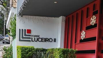 Un edificio con un letrero que dice 'TORRE LUCEIRO II' y una puerta roja con detalles decorativos.
